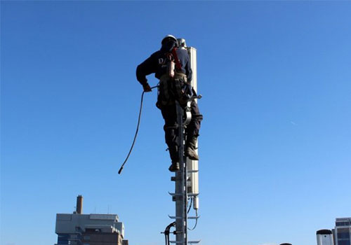 Storingsdienst mobiele operators. DAEL Telecom medewerker klimt hiervoor in een mast.